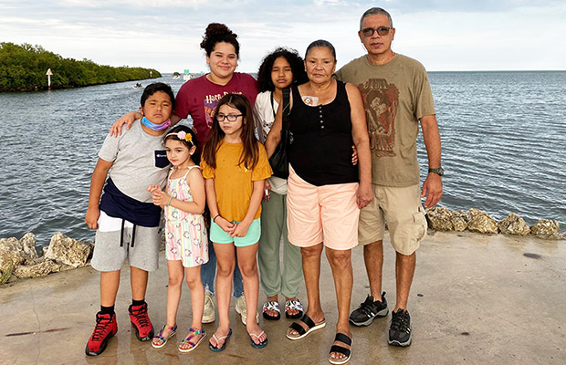 A group of seven people standing in front of the ocean