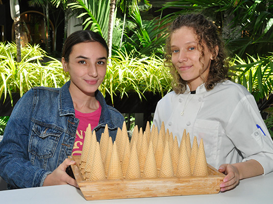 Two women holding up ice cream cones