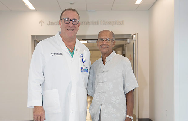 A doctor and patient standing next to each other, they smile at the camera