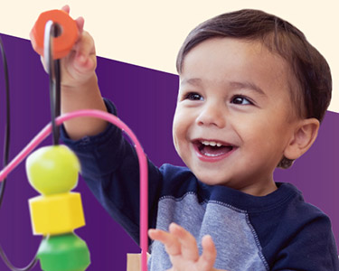 A young boy playing with a small toy