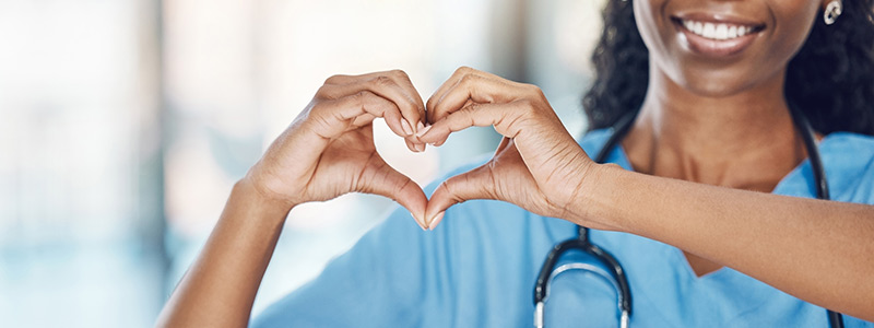 Closeup of a nurse making a heart shape with her hands
