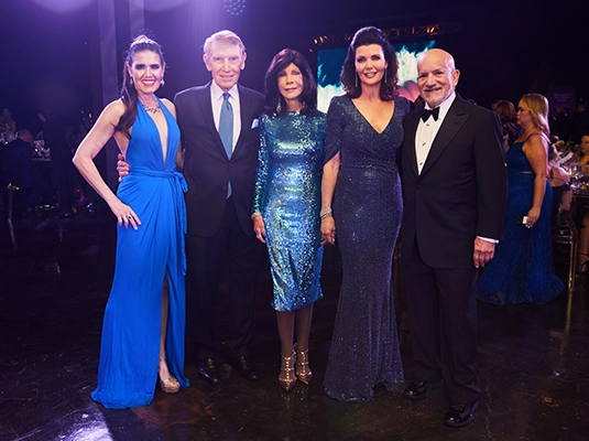 People posing to the camera during formal event