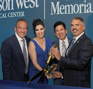 group of people cutting blue ribbon