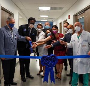 group of people cutting blue ribbon