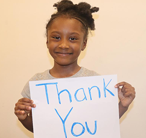 girl showing thank you sign