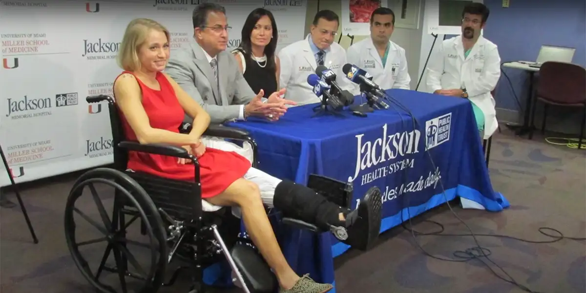 A group of medical professionals and a patient at a press conference