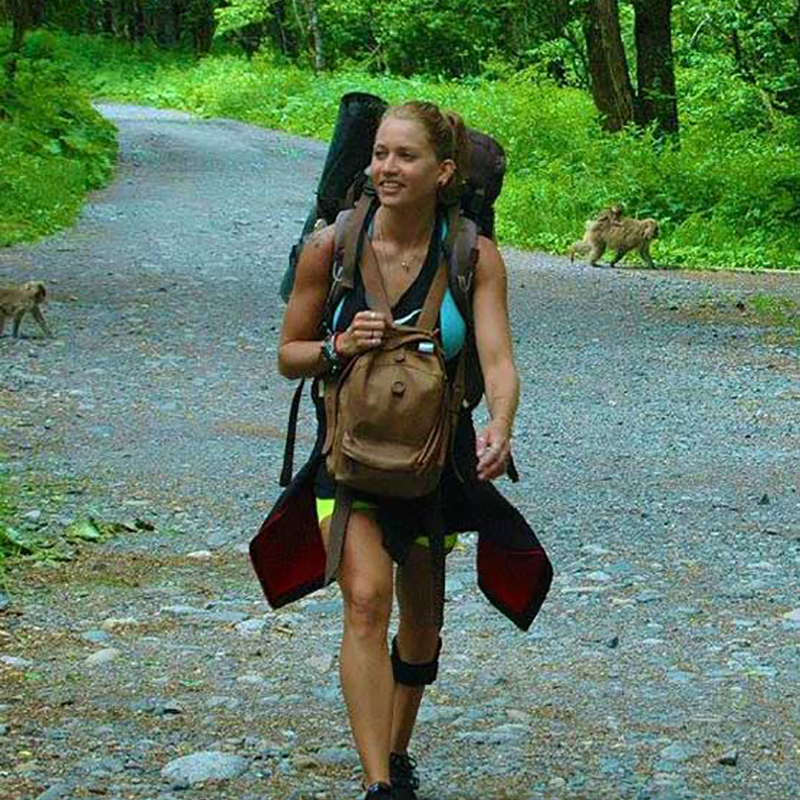 Danielle Press hiking outdoors, you can see two monkeys behind her