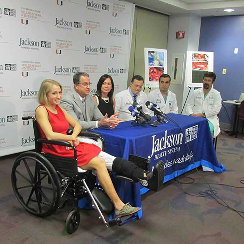 Danielle Press at a press conference, she is sitting on a wheelchair, doctors and Jackson employees sit beside her