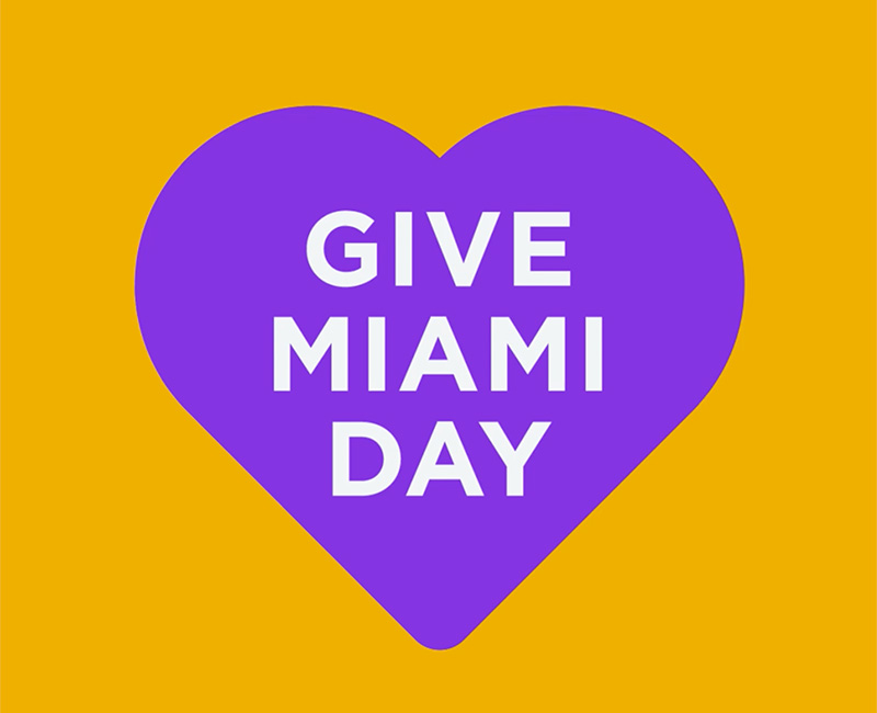A purple heart with white text that reads Give Miami Day