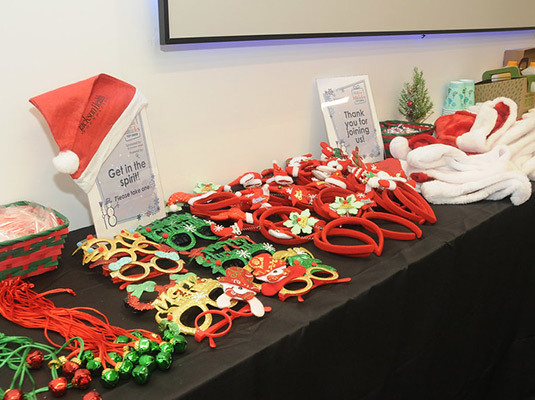 A table full of holiday headbands, hats, and glasses