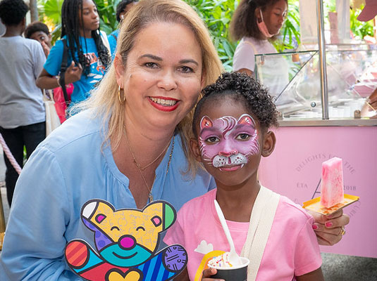 woman and girl with face painting smiling at camera