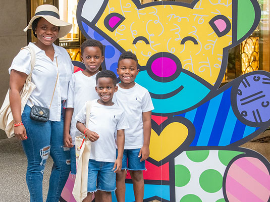 family posing next to colorful bear