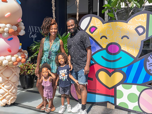family posing with colorful bear