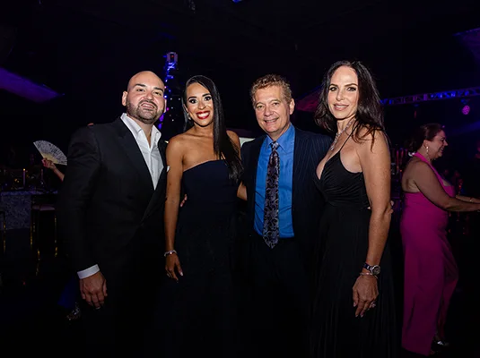 A group of four people, they are smiling at the camera