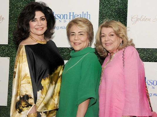 three women of different ages posing and smiling at the camera