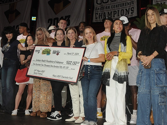 group of people showing giant check from platform