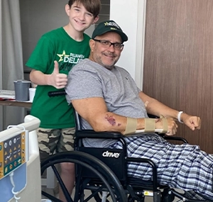 boy smiling next to man in wheelchair