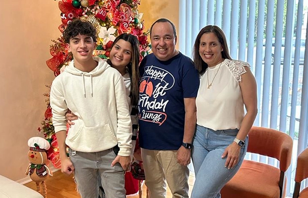 family group next to christmas tree