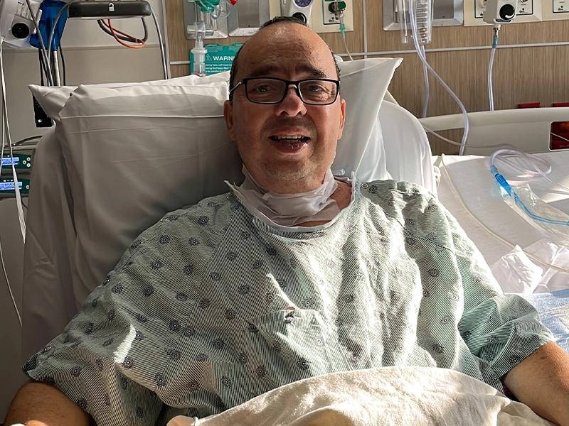 Man smiling from hospital gurney