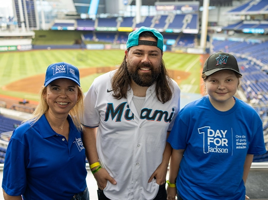 A man, a boy, and a woman at a baseball stadium