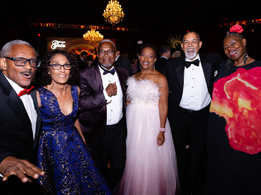 group of people dressed formally posing for the camera during an event