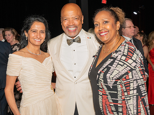 three people smiling and posing for the camera