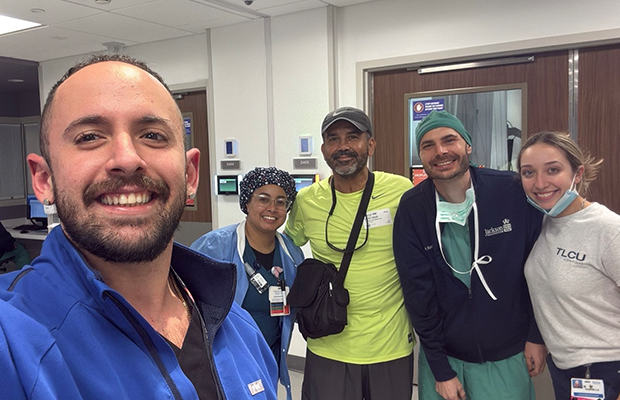 group of people smiling and posing in a hospital hallway
