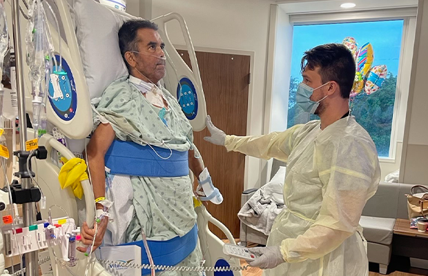 Man on a hospital stretcher being examined by a doctor