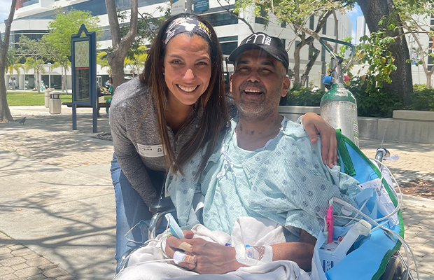man in a wheelchair next to a woman who hugs him