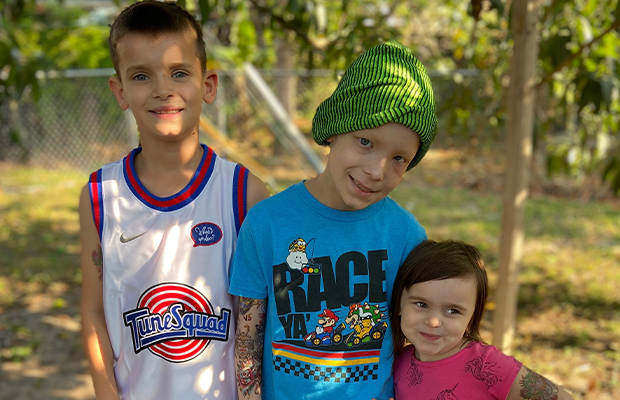 three children hugging, smiling and posing