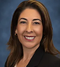 Close-up of a brown-haired woman smiling and a black suit