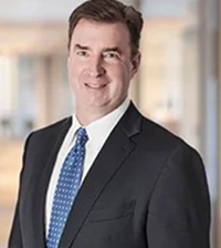 Close-up of a man wearing a suit and blue tie