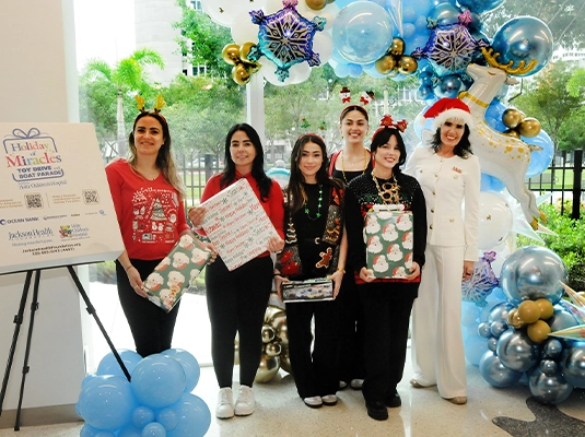 Six women posing for the camera during a formal celebration
