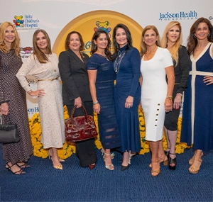 A gropu of women posing to the camera using dresses