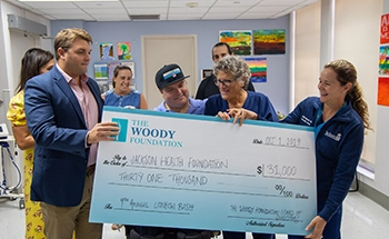 Man receiving a giant check alongside other people