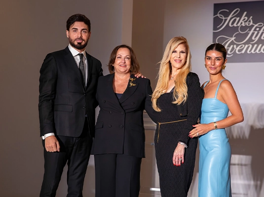 Four people dressed in formal attire posing for the camera during an event.
