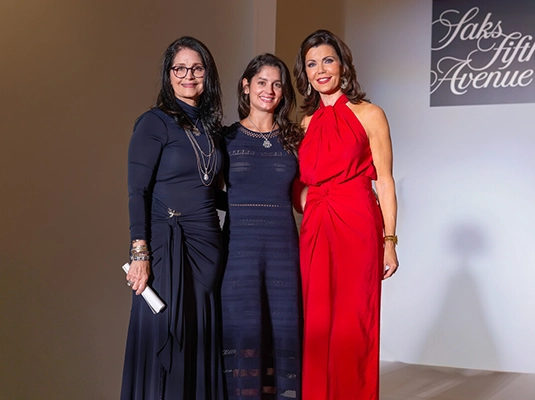 Three women in dresses posing for the camera.