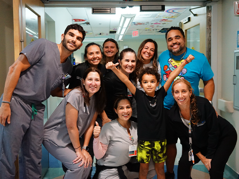 Photograph of a small child with medical personnel
