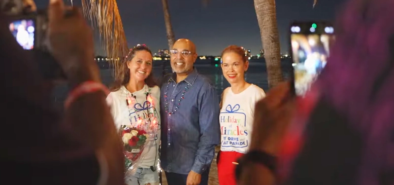 An image showing people being photographed on the beach at night.