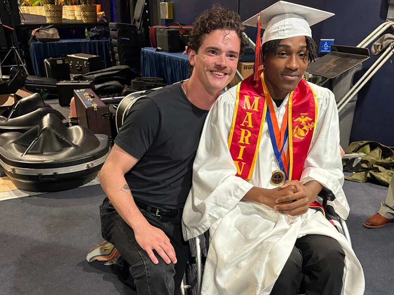 Man hugging young man in wheelchair