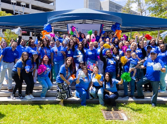 A large group of people posing for the camera, all wearing blue t-shirts.