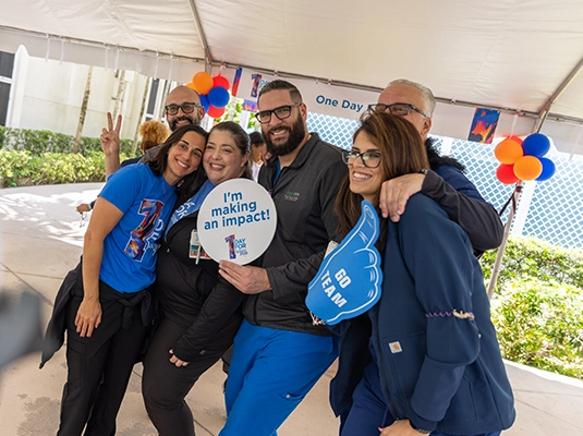 A group of people smiling and hugging while posing for the camera.