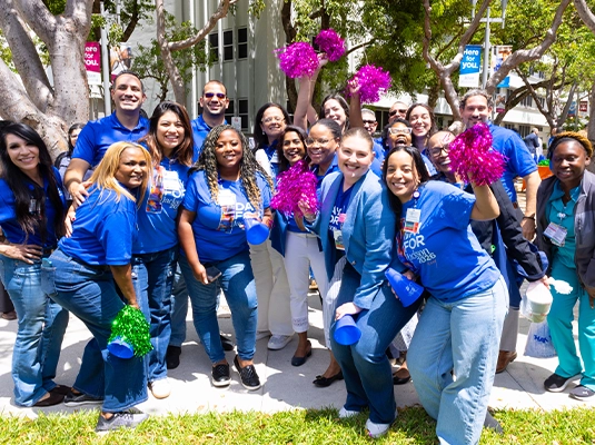 A large group of people posing for the camera, all wearing blue t-shirts.