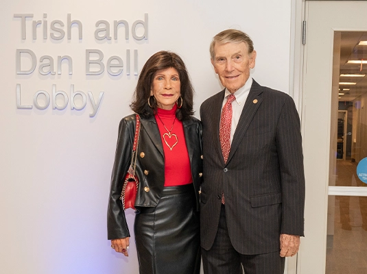 An older man and woman posing for the camera, elegantly dressed.
