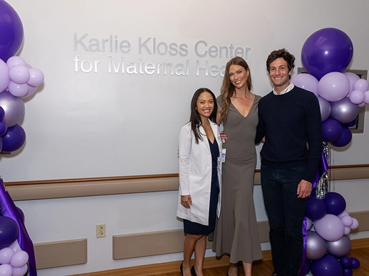 A man and a woman hugging a female doctor.