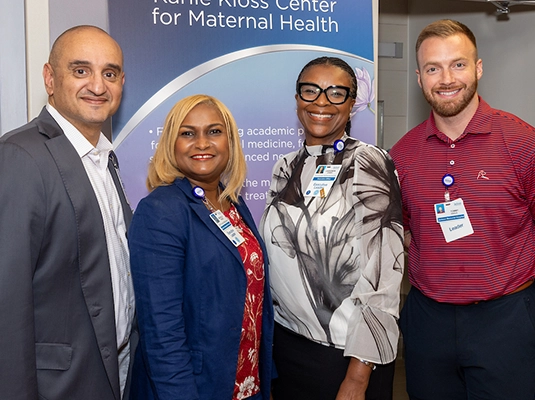 Two men and two women posing for the camera during an event.