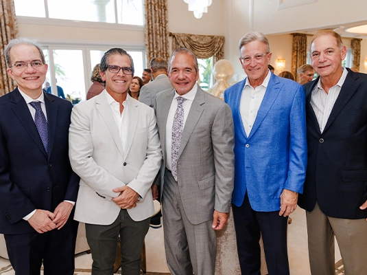 Five men in suits smiling at the camera.