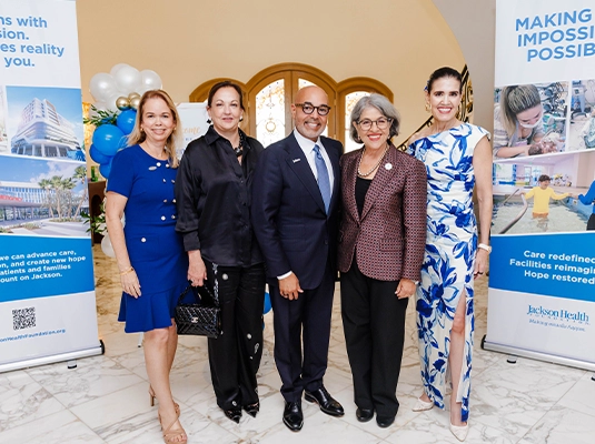 Five people dressed in formal wear smiling at the camera.