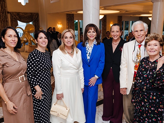 A large group of people posing and smiling at the camera during a gala event.