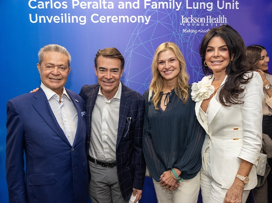 Four men and two women posing and smiling at the camera.